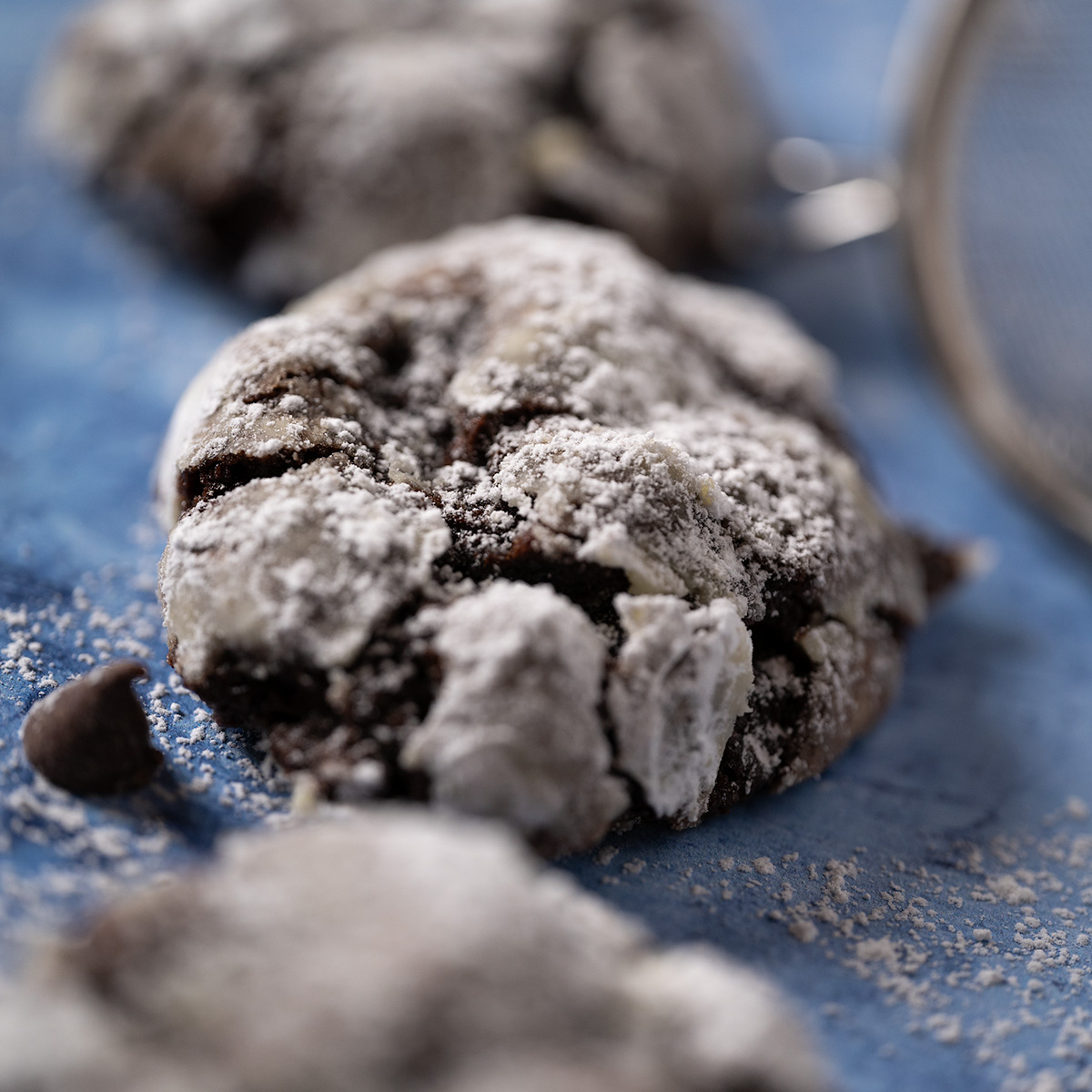 Macro shot of crinkle cookie on a blue background.