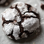 A close-up of a crinkle cookie with powdered sugar.