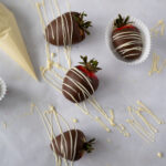 Four chocolate strawberries with fresh white chocolate drizzle.