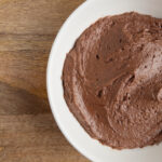 A bowl of chocolate buttercream frosting.