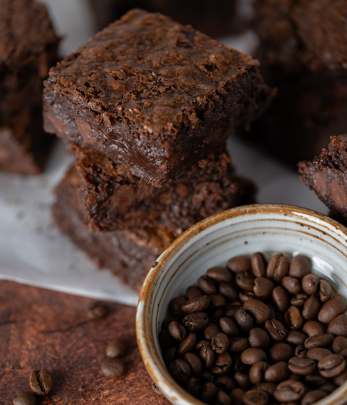 Espresso brownies next to a bowl full of fresh espresso beans.