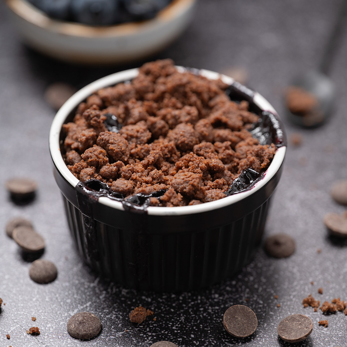 A macro shot of dark chocolate blueberry crisp.