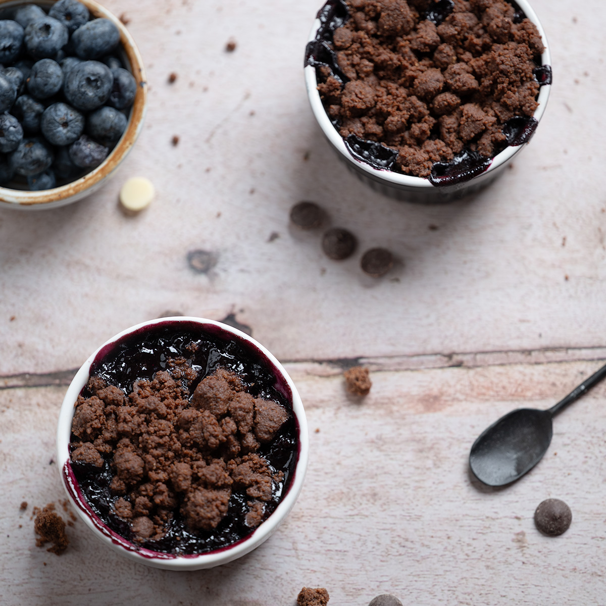 Close up of two ramekins of white chocolate blueberry crisp