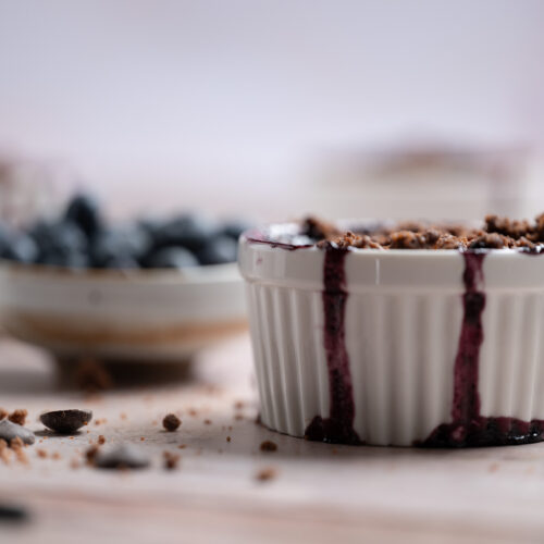 Two ramekins of chocolate blueberry crisp.