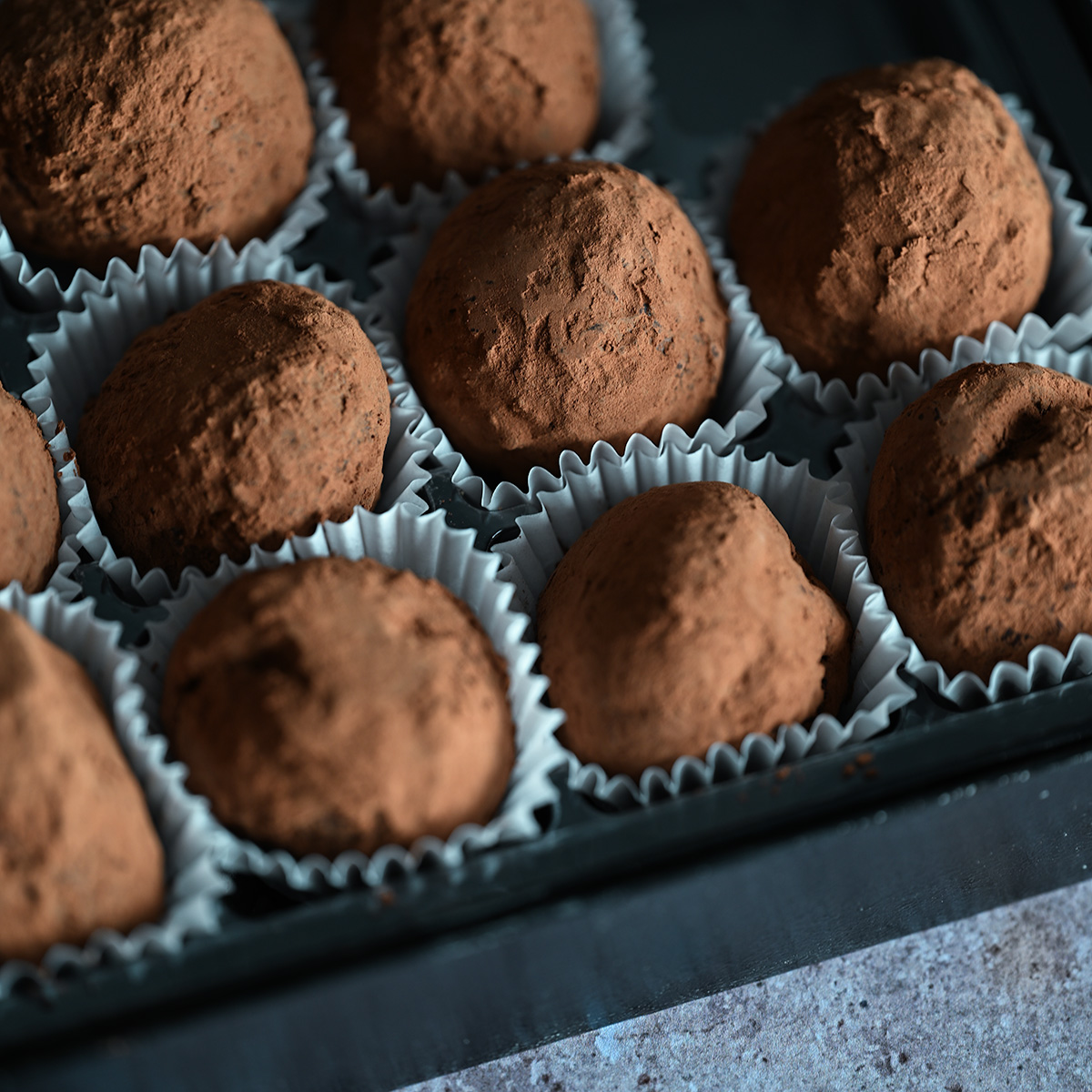 Macro shot of a box of classic dark chocolate truffles.